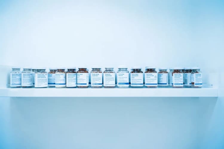 Uma prateleira de farmácia com vários frascos de medicamentos antidepressivos de primeira linha.